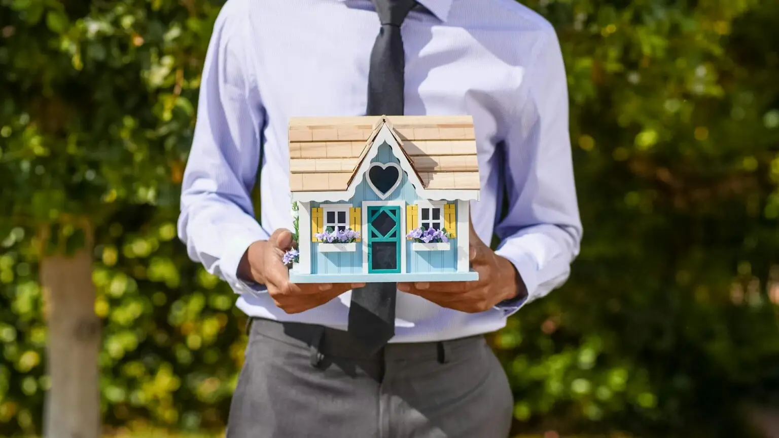 person holding a miniature house
